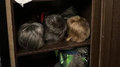 Izvestia A cupboard with several wigs inside