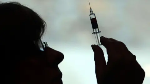 PA A nurse preparing to give a patient a vaccine