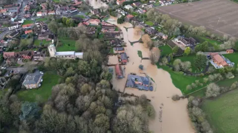 Aerial view of Lindholme in Scotter which was was hit by flooding from the River Eau in January brown water surrounds a number of houses 