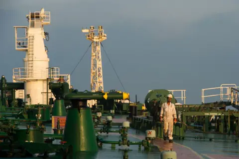 Bloomberg via Getty Images A crew man walks along the deck of oil tanker 'Devon' as it prepares to transport crude oil from Kharg Island to India in Bandar Abbas, Iran, on Friday, March 23, 2018. Geopolitical risk is creeping back into the crude oil market. Photographer: Ali Mohammadi/Bloomberg via Getty Images