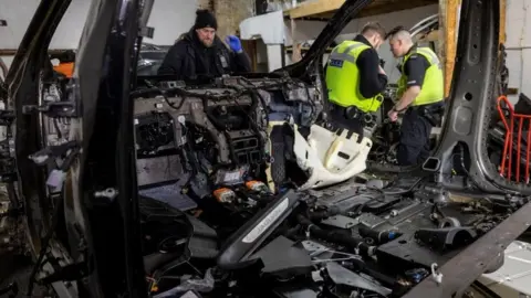 West Midlands Police Police officers at a so-called chop shop in Balsall Heath