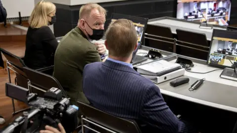 Reuters The trial of a Danish man (in the blue suit) who is suspected of murder and attempted murder of a German couple on board the Viking Sally ferry in the summer of 1987, 24 May 2021