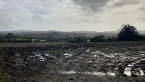 BBC Muddy field and hills in the background