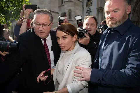 George Cracknell Wright Coleen Rooney and Wayne Rooney leave the Royal Courts of Justice surrounded by the press