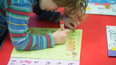 Getty Images Child writing letters at nursery