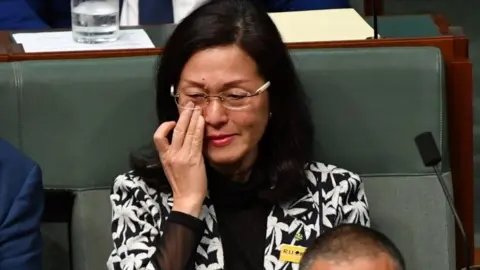 EPA Gladys Liu wipes away a tear while sitting in Australia's parliament