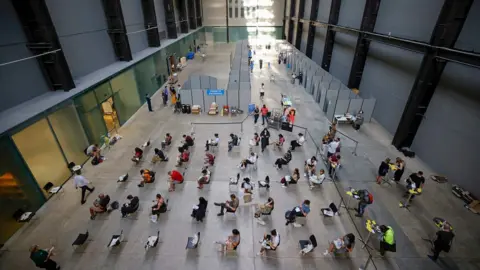 Getty Images Vaccination queues at the Tate Modern in London