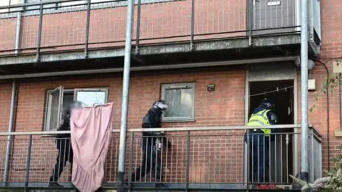 CHESHIRE POLICE Cheshire Police entering a house to make an arrest