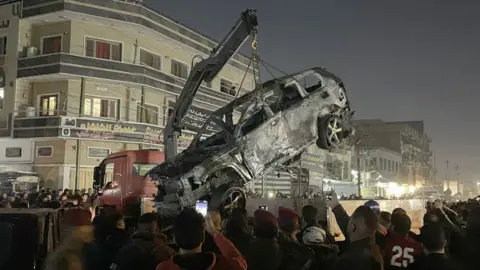 Getty Images The destroyed car being lifted on a crane