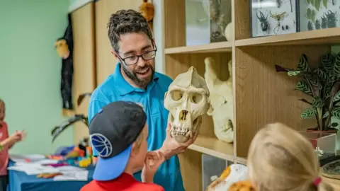 Chester Zoo Chester Zoo education expert showing two children an animal's skull