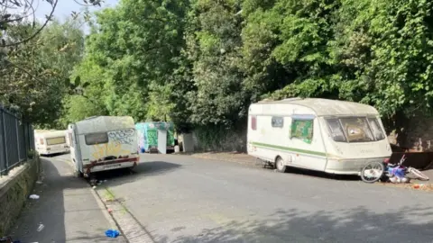 Vans and caravans parked on the road