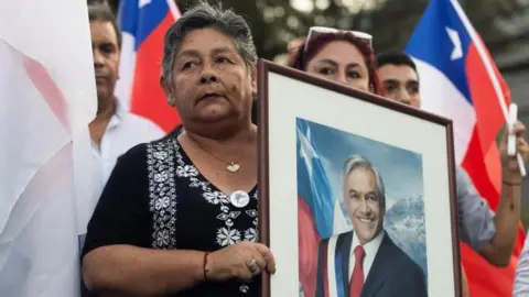 Supporters of Chile's former President Sebastian Pinera gather to mourn at the headquarters of the National Renewal party, after Pinera died in a helicopter crash, in Santiago, Chile February 6, 2024.