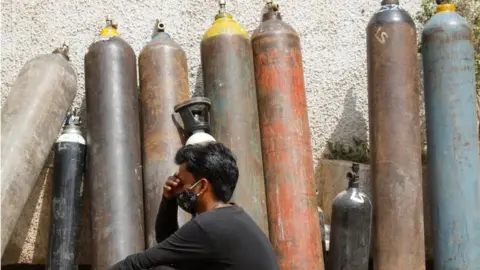 Reuters A man waits outside a factory to get his oxygen cylinder refilled, amidst the spread of the coronavirus disease (COVID-19) in New Delhi, India, April 28, 2021. REUTERS/Adnan Abidi