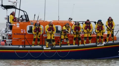 Caron Hill/RNLI The lifeboat crew drop flowers into the sea