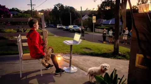 AFP Jude Fell, aged 10, plays The Last Post on a saxophone from his driveway at dawn in Sydney on April 25, 2020