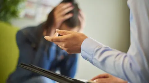 Getty Images A distressed woman with a counsellor