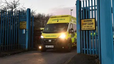 Getty Images photo of an ambulance driving through blue gates.