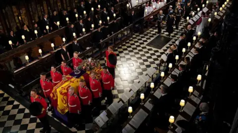 Reuters The coffin of Queen Elizabeth II is carried into St George's Chapel in Windsor followed by members of the Royal Family