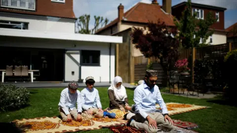 Reuters A family perform Eid prayers at home during the coronavirus pandemic