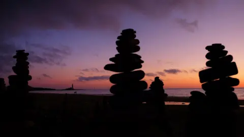 Owen Humphreys/PA Media Pebble towers at sunrise