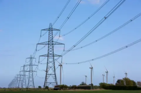 Getty Images Power pylons and a wind farm