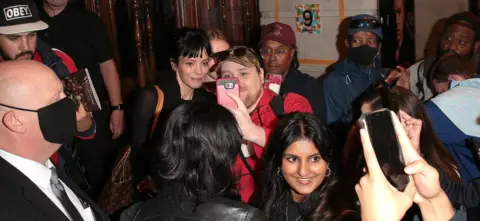 Getty Images Lily Allen outside the Noel Coward Theatre, taking selfies with fans