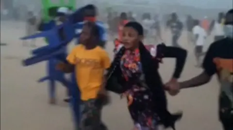 A blurry screengrab shows people running away.