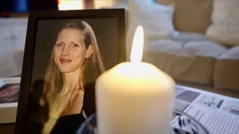 A portrait of Amanda Walker with a candle in front of it