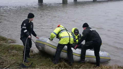 People with high vis jackets moving a boat