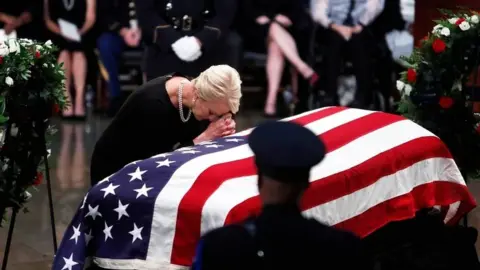 Reuters Cindy McCain leans over his casket as his body lies in state inside the US Capitol in Washington on 31 August 2018