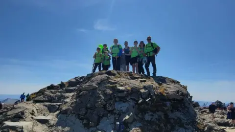 Derian House Oscar and family at mountain top