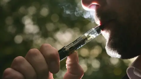 PA Media Generic image of a man smoking an electronic cigarette