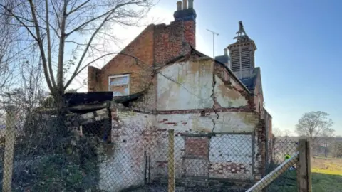 Talbot Homes Side view of two-storey brick building, showing crumbling exterior wall