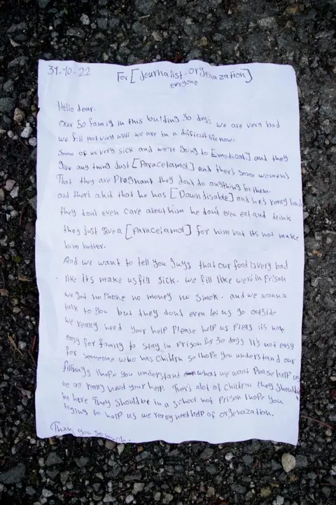 PA Media A letter thrown by a young girl over the fence at the Manston immigration short-term holding facility located at the former Defence Fire Training and Development Centre in Thanet, Kent