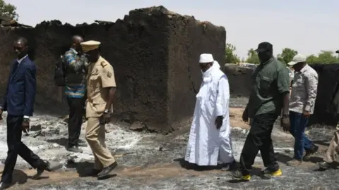 Reuters President Ibrahim Boubacar Keita inspects the damage after an attack by gunmen on Fulani herders in Ogossagou, Mali 25 March 2019