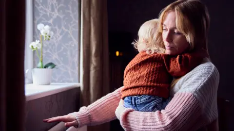 Getty Images Woman with child at radiator