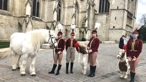 Circus performers and horses gather outside Gloucester Cathedral for the funeral of Nell Gifford