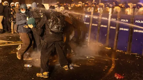 EPA Turksih riot police spray demonstrators to block them as they march to Taksim Square from the Istanbul Municipality headquarters during a protest against the detention of Istanbul Mayor Ekrem Imamoglu, in Istanbul, Turkey, 21 March 2025.