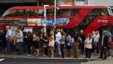 Getty Images Commuters wait for London bus