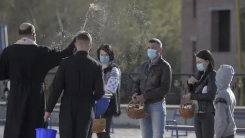EPA An Orthodox priest blesses believers in Lviv, Ukraine. Photo: 18 April 2020