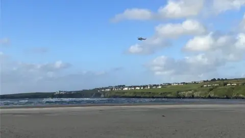 Millie Cook    A helicopter was seen hovering over the beach after Mr Morgan rescued the children