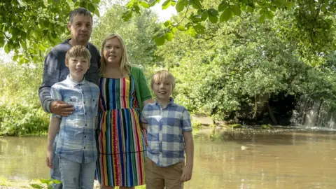 Donna Kelly Donna and her family standing on a riverbank