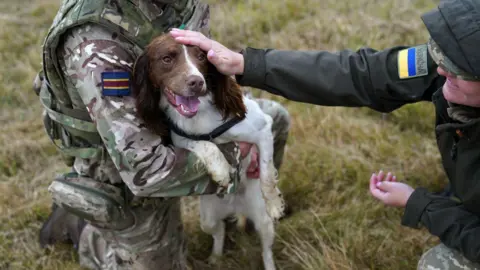 PA Media British Army dog handlers with a dog