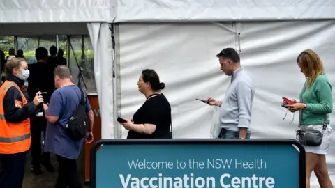 EPA A queue of people waiting to get vaccinated at a mass vaccination hub in Sydney