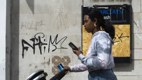 Getty Images Woman walking looking at phone