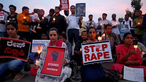 Reuters People participate in a candle light vigil as they protest against the rape of an 8-year-old girl in Kathua near Jammu, and a teenager in Unnao, Uttar Pradesh state, in Bengaluru, India on 13 April 2018