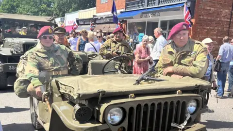 Woodhall Spa 1940s Festival 2022 People dressed as wartime soldiers sitting on military vehicles