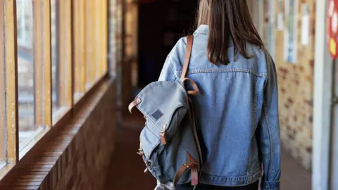 Getty Images Girl walking down a school corridor