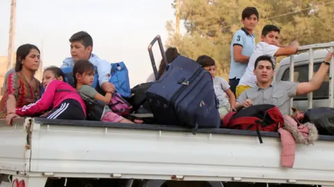 EPA Families flee the town of Ras al-Ain in north-east Syria (10 October 2019)