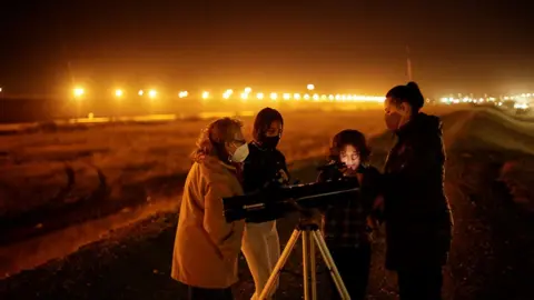 Jose Luis Gonzalez / Reuters A family with a telescope in Ciudad Juarez, Mexico